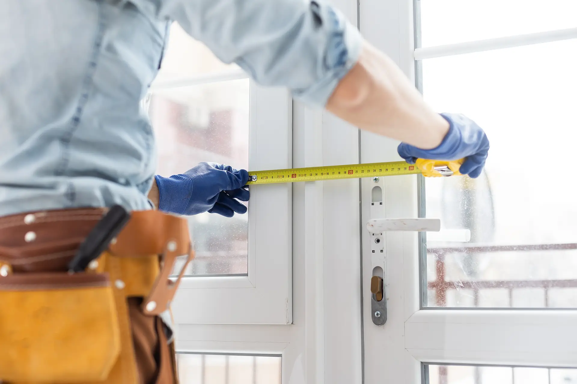 Worker measuring glass door – Gabes Pty Ltd pre-clean & detailing for commercial fit-outs and window installations